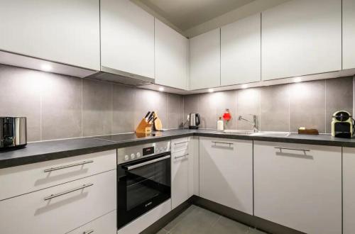 a large white kitchen with white cabinets and appliances at Stylish Lakeside Home by the Jet d'Eau in Geneva