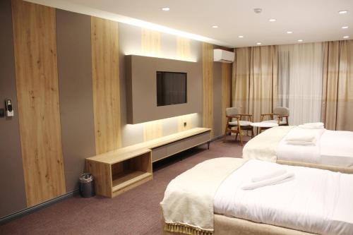 a hotel room with two beds and a flat screen tv at Sabiha Sultan Hotel-Karakoy in Istanbul