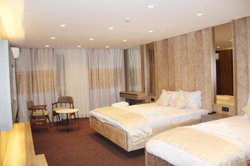 a hotel room with two beds and a table and chairs at Sabiha Sultan Hotel-Karakoy in Istanbul