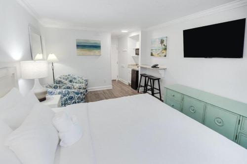 une chambre avec un grand lit blanc et un bureau dans l'établissement Ultimate Getaway Resort View King Room 1st Flr, à Pawleys Island