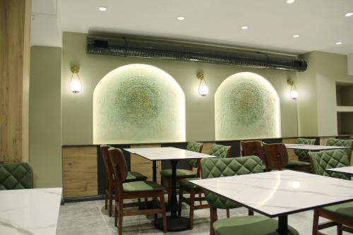 Sabiha Sultan Hotel-Karakoy في إسطنبول: مطعم بطاولات وكراسي ونوافذ مقوسة ثلاثية