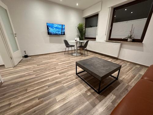 a living room with a table and chairs and a table and a couch at Schöne, moderne Wohnung mit Waldblick & Parkplatz in Melle