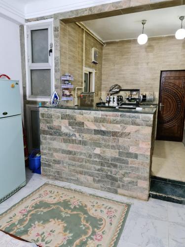 uma cozinha com um balcão de tijolos e um frigorífico em Happy pyramids inn Hotel no Cairo