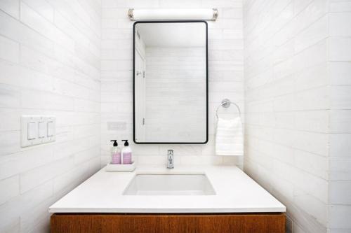 a white bathroom with a sink and a mirror at Spectacular Studio in Manhattan in New York