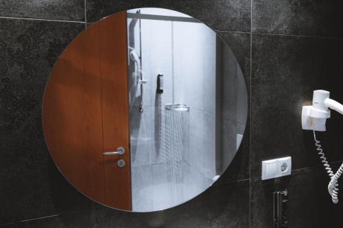 a bathroom with a round mirror and a phone at Anewandterhof in Brunico