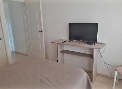 Zimmer mit einem Tisch und einem TV darauf in der Unterkunft Departamentos Vila in Mina Clavero