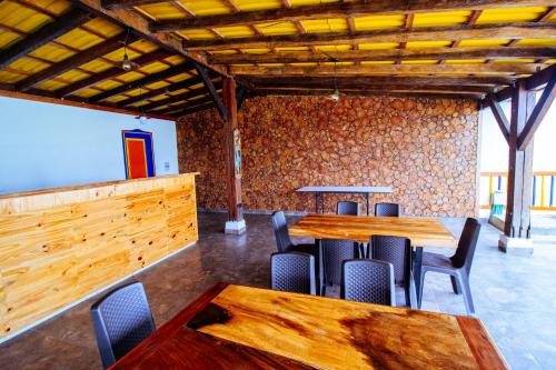 a restaurant with wooden tables and chairs in a room at Finca Nuevo Monarca in Pereira