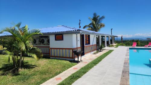 a house with a swimming pool in front of it at Finca Nuevo Monarca in Pereira