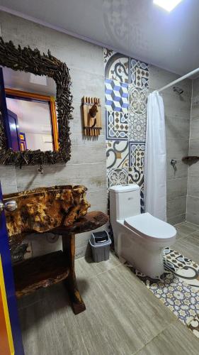 a bathroom with a toilet and a sink and a mirror at Finca Nuevo Monarca in Pereira