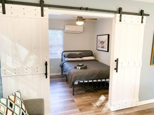 a bedroom with a bed and a sliding barn door at Tiny house- near Duke Univ/Hospital, walk to food in Durham