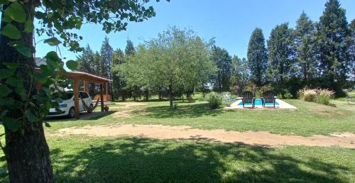 een park met een speeltuin met een trampoline bij La Cabañita in Colonia Caroya