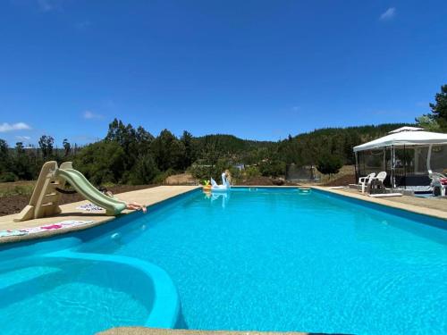 a large blue swimming pool with a slide and a slidesktop at Hotel Boutique Las Taguas in Constitución