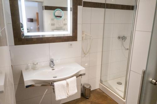 a bathroom with a sink and a shower at Hotel Daniel in Munich