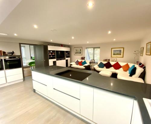 a large living room with a couch and a kitchen at Silvercopse House in Kingston Bagpuze