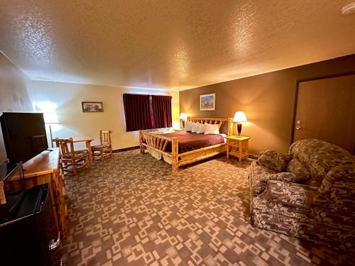 une chambre d'hôtel avec un lit et un canapé dans l'établissement FairBridge Inn, Suites & Conference Center – Missoula, à Missoula