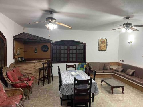 a living room with a couch and a table at Maravilhosa Casa a 20 Metros da PRAIA in Caraguatatuba