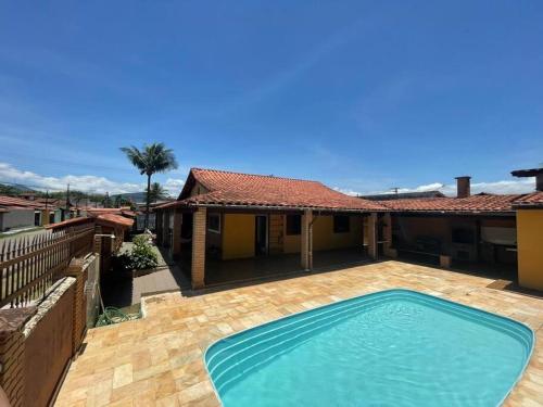 a swimming pool in the backyard of a house at Maravilhosa Casa a 20 Metros da PRAIA in Caraguatatuba