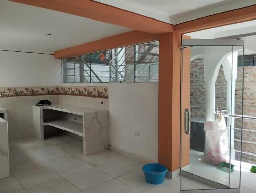 a kitchen with a desk and a glass door at Kutimuy in Ayacucho