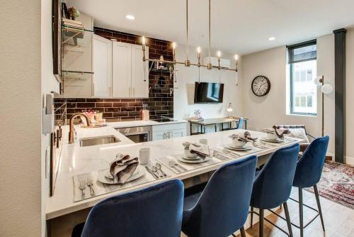 a kitchen with a long table with blue chairs at VRAIN 2 Bedroom 1 Bath with Full Kitchen in Denver