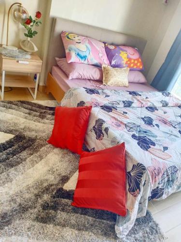 a bedroom with a bed with red pillows on it at Unit 3J Signature Suites, Lafayette Megaworld in Iloilo City