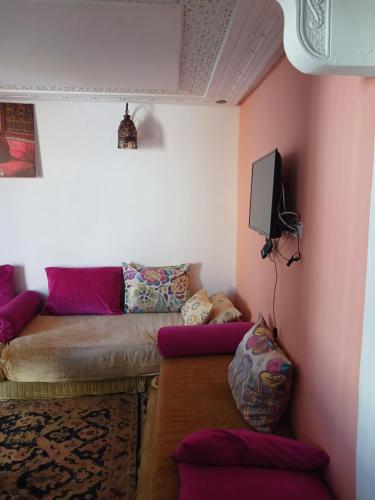 a living room with a couch and a tv at Studio Amine avec une terasse privée in Rabat