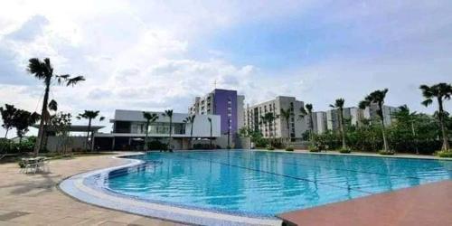 a large swimming pool in front of a city at Aeropolis Apartemen in Teko
