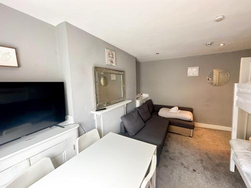 a living room with a couch and a flat screen tv at Stay In Oxford Street in London