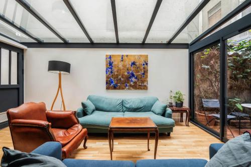 un salon avec un canapé et une table dans l'établissement Appartement de l'Artiste - Welkeys, à Paris