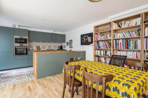 une cuisine et une salle à manger avec une table et des chaises dans l'établissement Appartement de l'Artiste - Welkeys, à Paris