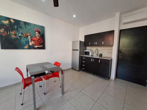 uma cozinha com uma mesa e cadeiras vermelhas num quarto em Condo Kiaraluna em Playa del Carmen