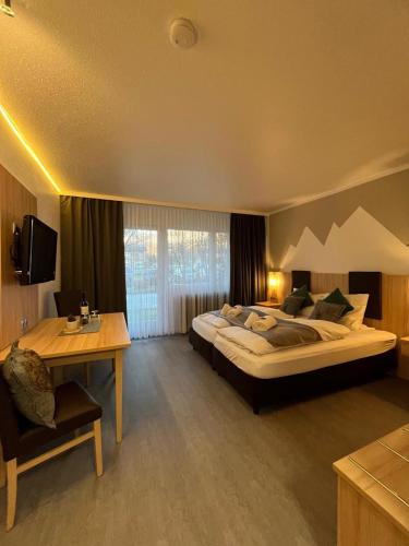 a large bedroom with a large bed and a desk at Alpenstubn - Chiemgau Karte in Inzell