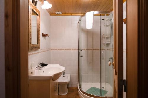 a bathroom with a shower and a sink and a toilet at Villa Mistério in São Roque do Pico