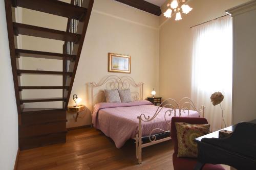 a bedroom with a pink bed and a staircase at Agriturismo Villa Marta in Cesena