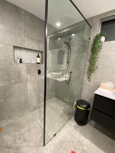 a bathroom with a glass shower with a sink at The Beach House @ Primrose Sands in Primrose Sands