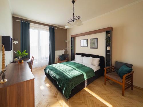 a bedroom with a bed and a table and a chair at Loggia Apartman in Győr