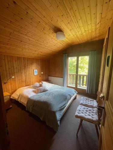 1 dormitorio con 1 cama grande y techo de madera en Chalet familial pour l'été, en Troistorrents