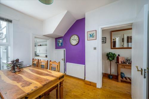 a dining room with a table and a clock on a wall at The Music and Poetry House in Belfast