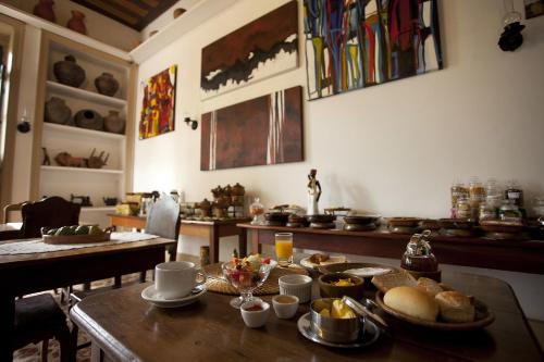 a kitchen with a table with food on it at Pousada dos Quatro Cantos in Olinda