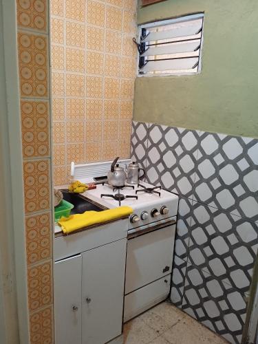 a small kitchen with a stove and a sink at La Perla alojamiento in Mar del Plata