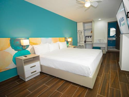 瓜達拉哈拉的住宿－Vista Express Guadalajara Expo，卧室配有白色的床和蓝色的墙壁