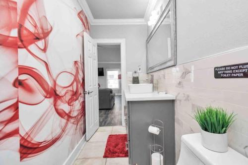 La salle de bains est pourvue d'une peinture rouge sur le mur. dans l'établissement Prolific Red Luxe: Private Deck + Stylish Living, à Houston