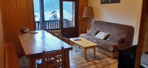 un salon avec un canapé et une table dans l'établissement Appartement 6 personnes à Saint-Jean-De-Sixt, Navette gratuite vers La Clusaz et Le Grand Bornand, à Saint-Jean-de-Sixt