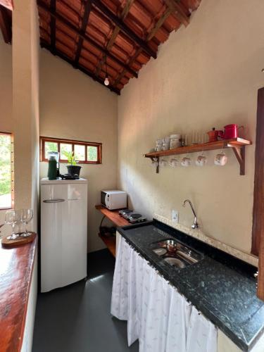 a kitchen with a sink and a refrigerator at Reserva do Bosque Hospedaria e Natureza in Ibicoara