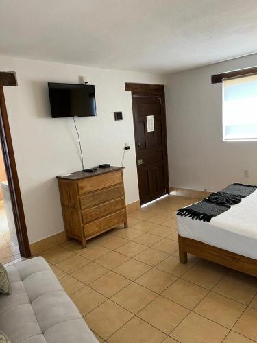 a bedroom with a bed and a tv on the wall at Hotel Jardín del Cantador in Guanajuato