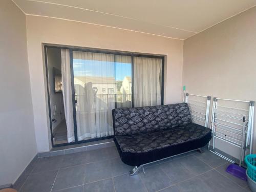 a couch in a room with a large window at Leisure apartment in Ballito