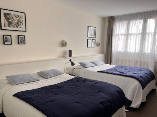 two beds sitting next to each other in a room at Le Téméraire Hôtel in Charolles