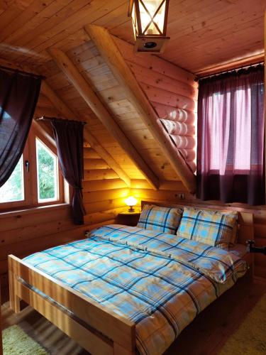 ein Schlafzimmer mit einem Bett in einem Blockhaus in der Unterkunft Apartments Greenstone in Kolašin