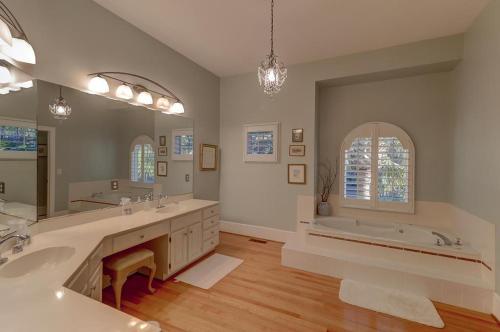 uma casa de banho com 2 lavatórios, uma banheira e um espelho grande em 17 56th Avenue em Isle of Palms