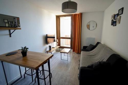 a living room with a couch and a table at Val Thorens Studio 2 personnes et balcon plein Sud in Val Thorens