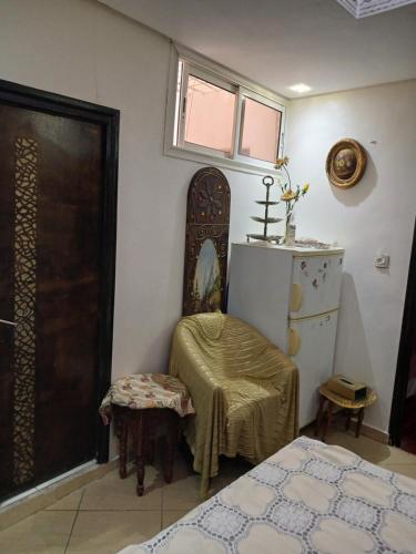 a room with a bed and a chair and a door at Dar Amine in Rabat